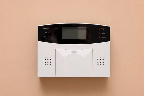 Home security alarm system on beige wall