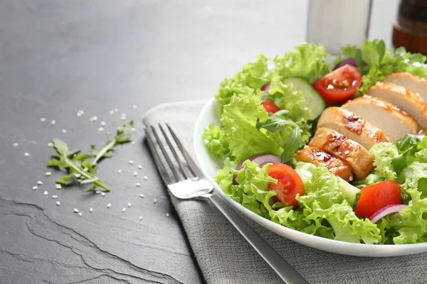 Siyah masada servis edilen tavuk ve sebzeli leziz salata, yakından. Metin için boşluk