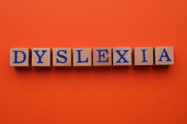 Turuncu arka planda kelime disleksisi olan tahta küpleri düz yatıyordu.