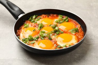 Lezzetli Shakshuka kızartma tavasında açık gri masada, yakın plan