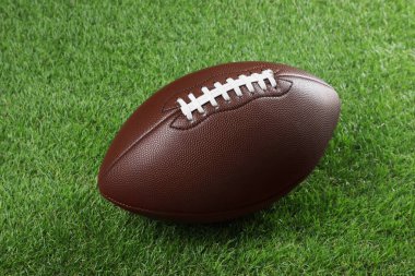 Yeşil çimlerin üzerinde kahverengi deri Amerikan futbol topu