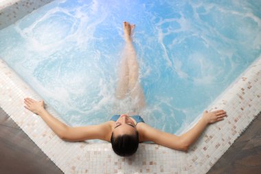 Güzel bir kadın, spa havuzunda dinleniyor, manzaralı.