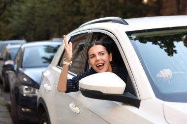 Trafik sıkışıklığında kızgın sürücü arabadan birine bağırıyor.