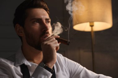 Evde puro içen yakışıklı bir adam. Metin için boşluk