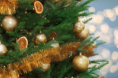Bulanık arka planda altın şenlik toplarıyla süslenmiş Noel ağacı, bokeh etkisi. Metin için boşluk