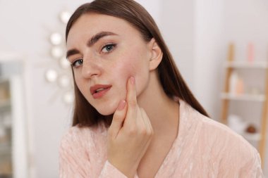 Evde cilt sorunu olan genç bir kadın var.