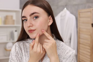 Banyoda cilt sorunu olan genç bir kadın.