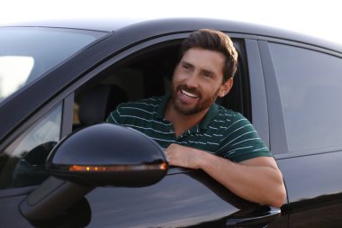 İyi yolculuklar. Arabasını kullanan mutlu sakallı adam, dışarıdan manzaralı.