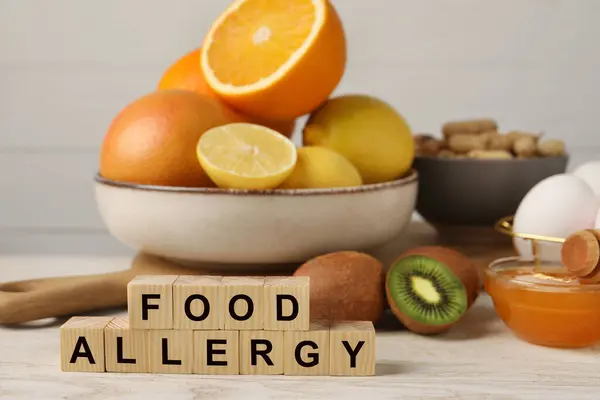 Food allergy. Different fresh products and cubes on light wooden table