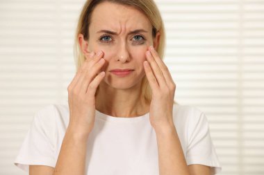 İçerde ağlayan maskaralı üzgün kadın.