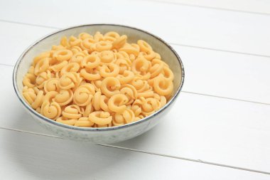 Raw dischi volanti makarna kasede beyaz ahşap masada, yakın plan