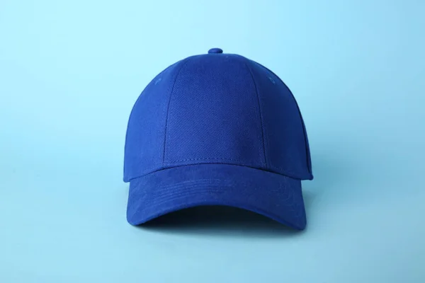 Stylish baseball cap on light blue background