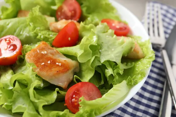 Delicious salad with chicken and cherry tomato on table, closeup