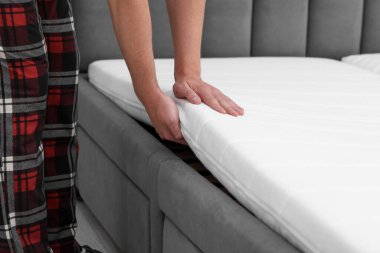 Yumuşak yatağı yatağa koyan adam, yakın plan.