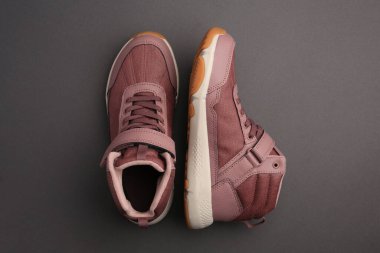 Siyah arka planda bir çift şık çocuk ayakkabısı.