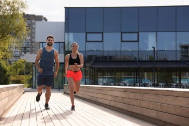 Sağlıklı bir yaşam tarzı. Güneşli bir günde dışarıda koşan mutlu çift, mesaj için yer var.