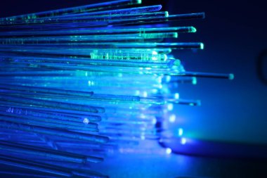Optik fiber iplikler bulanık arkaplan ve makro görünüme karşı farklı renk ışıkları iletiyor