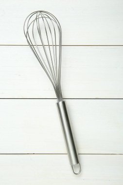 Beyaz ahşap masa üzerinde metal çırpma, üst görünüm