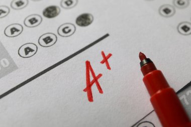 Okul derecesi. Cevap kağıdında artı işareti olan A harfi ve kırmızı işaret, yakın plan.