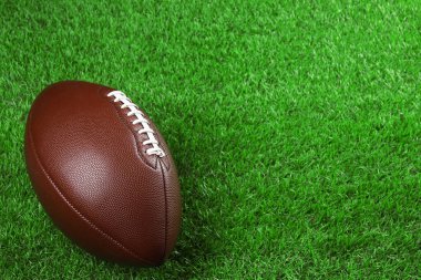 Amerikan futbol topu yeşil çimlerin üzerinde. Metin için boşluk