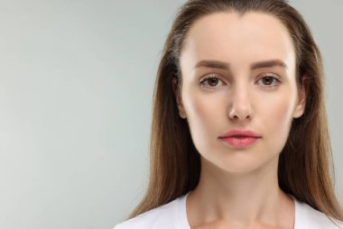 Açık gri arka planda güzel bir kadının portresi. Metin için boşluk