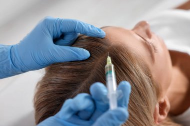 Trikoloğum klinikteki hastaya iğne yapıyor.