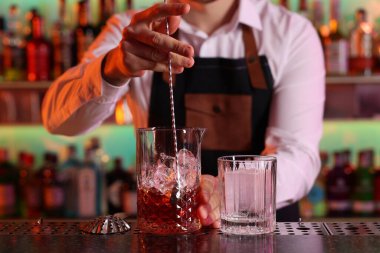 Barmen barda taze alkollü kokteyl hazırlıyor.