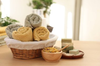 Kuru çiçekler, sabun barları ve havlular kapalı bir masa, yazı için yer. Spa zamanı