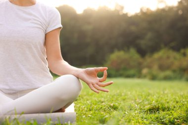 Paspasda yoga yapan bir kadın, yakın çekim ve mesaj için yer. Lotus pozu