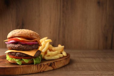 Et pirzolası ve ahşap masada patates kızartması ile nefis bir burger, mesaj için yer var.