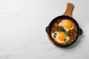 Beyaz mermer masada tavada harika bir Shakshuka, üst manzara. Metin için boşluk
