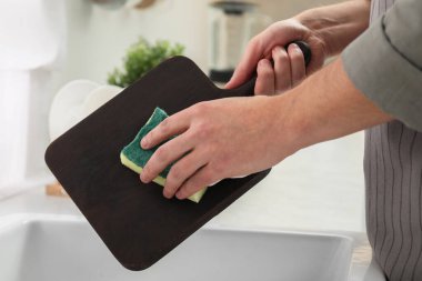 Mutfakta lavaboda odunları yıkayan adam, yakın plan.