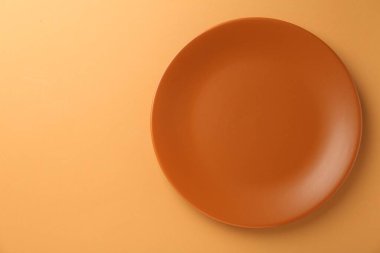 Turuncu arka planda güzel bir seramik plaka, üst manzara. Metin için boşluk