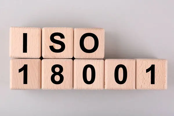 International Organization for Standardization. Wooden cubes with abbreviation ISO and number 18001 on light grey background, flat lay