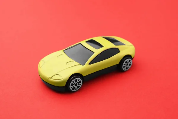 One yellow car on red background. Children`s toy