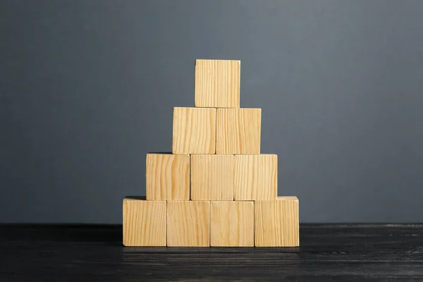 Pyramid of blank cubes on dark wooden table