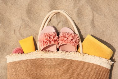 Kumsaldaki aksesuarlı şık bir çanta.