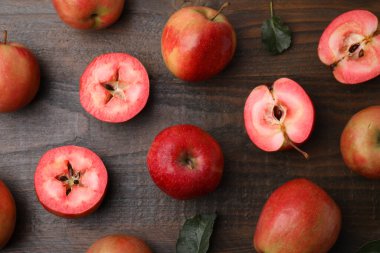 Lezzetli elmalar kırmızı hamurlu ve ahşap masa üzerinde yapraklar, düz yatıyordu.