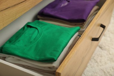 İçerideki çekmecede yığınla katlanmış gömlek var. Giysileri düzenleme