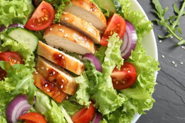 Tavuk ve sebzeli nefis salata, siyah masa, üst manzara.