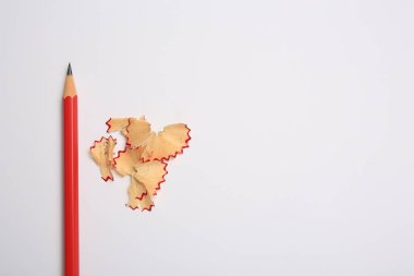 Graphite pencil and shavings on white background, flat lay. Space for text