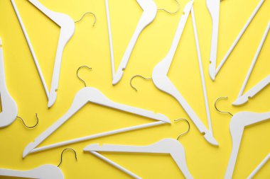 Sarı arka planda beyaz askılar, düz yatış