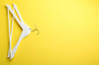 Sarı arka planda beyaz askılar, üst manzara. Metin için boşluk