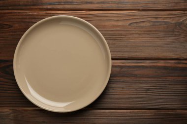 Ahşap masada güzel bej seramik tabak, üst manzara. Metin için boşluk