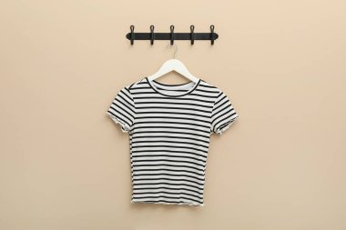 Bej duvarda çizgili tişört askısı
