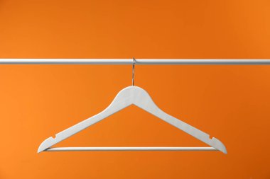 Boş elbise askısı turuncu arka planda asılı