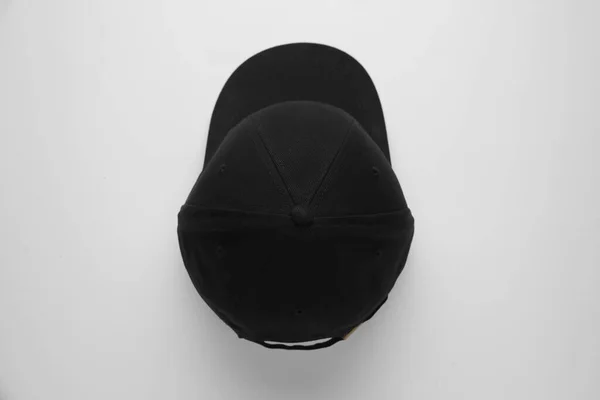 Stylish black baseball cap on white background, top view