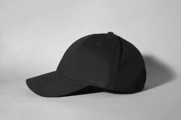 Stylish black baseball cap on grey background