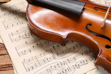 Keman ve müzik kağıtları ahşap masada, yakın plan.