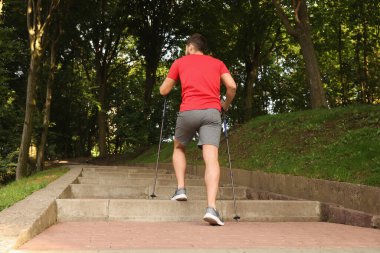 İskandinav usulü yürüme pratiği yapan bir adam.